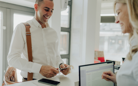Attendee receiving credentials at an early check-in desk