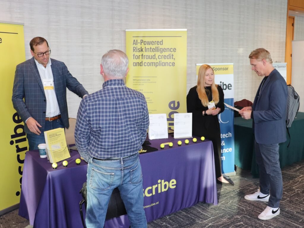Sponsor engaging with attendees at exhibit table during CU Growth & Innovation Summit